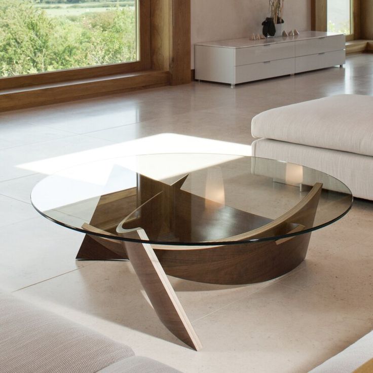 a glass table sitting on top of a living room floor next to a white couch