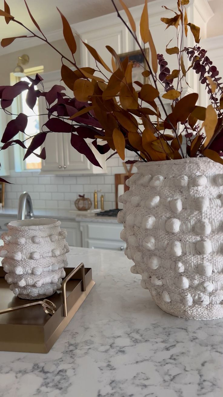 a vase filled with lots of white balls on top of a counter next to a sink