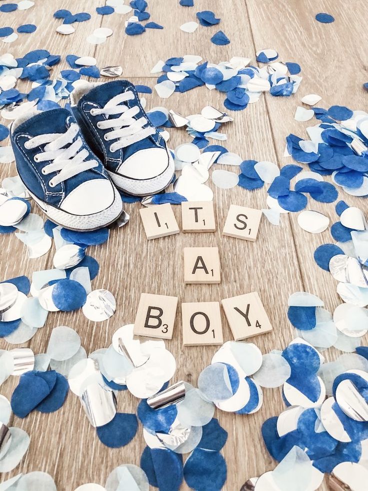 it's a boy spelled out with wooden blocks and blue confetti on the floor