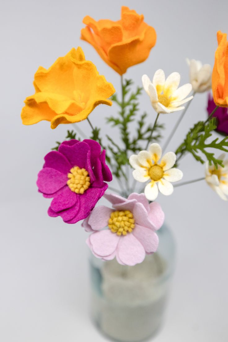 a vase filled with colorful flowers on top of a table