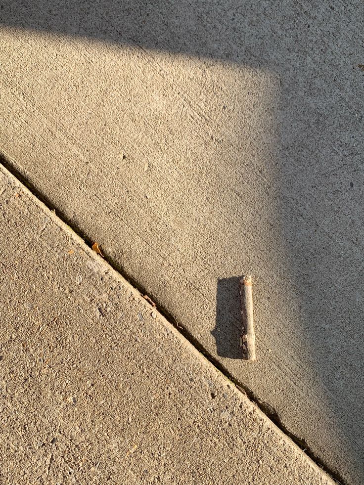 the shadow of a person walking down a sidewalk