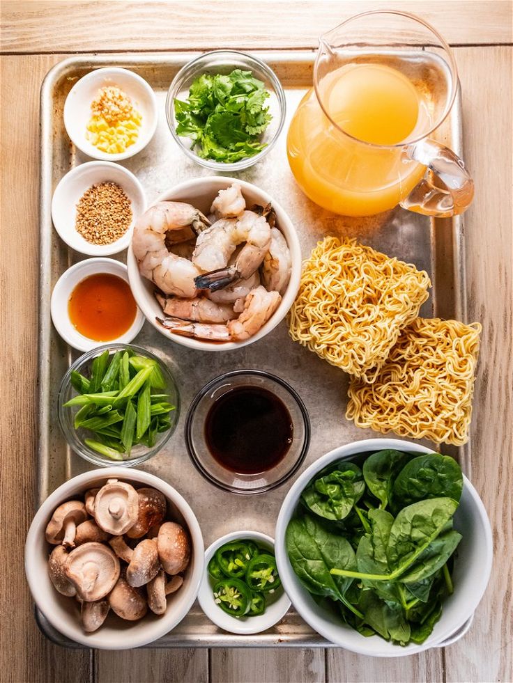 a tray filled with different types of food and drinks on top of a wooden table