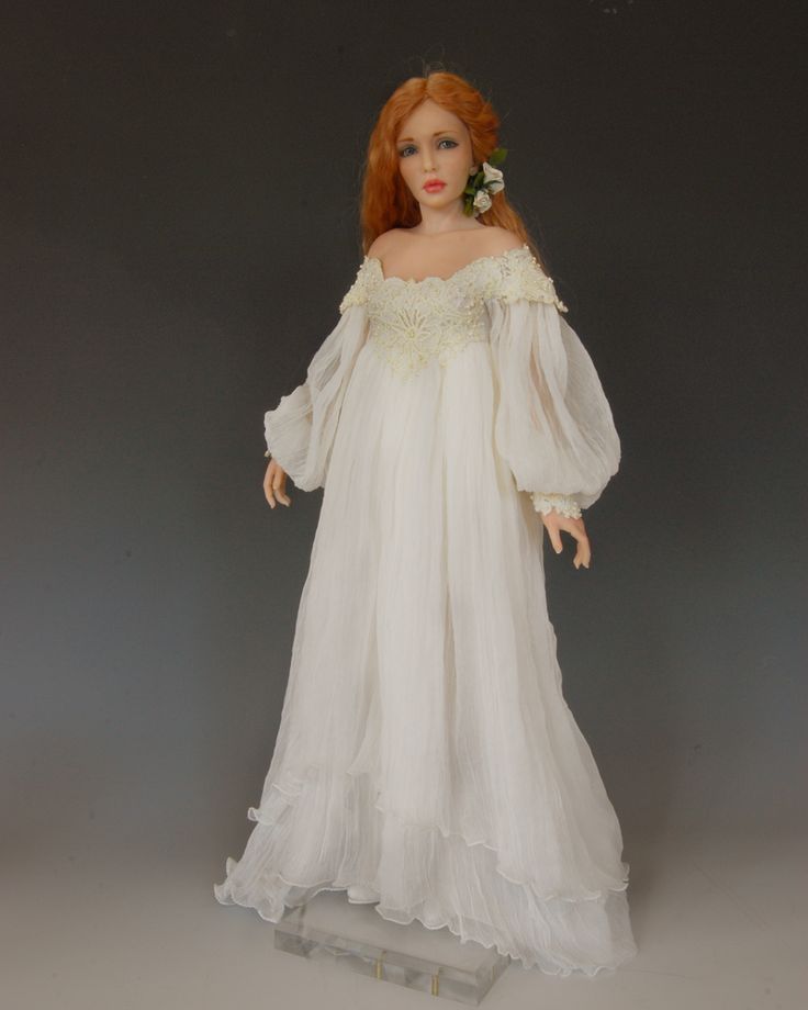 a doll with red hair wearing a white dress