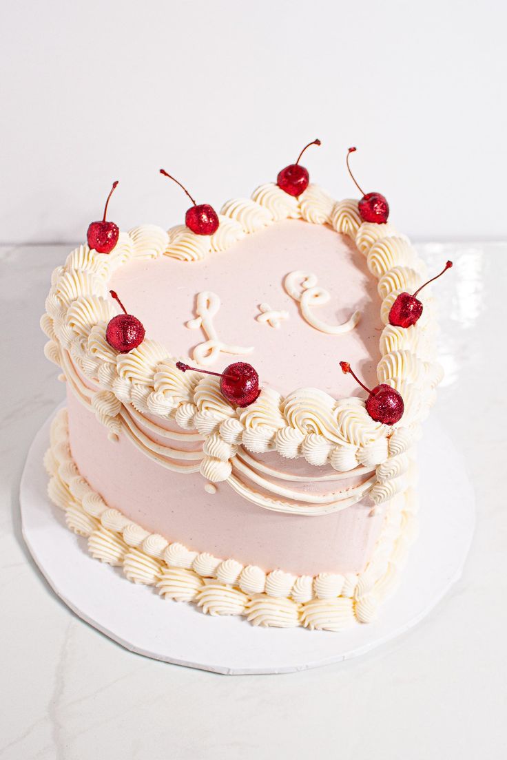 a heart shaped cake with cherries on top