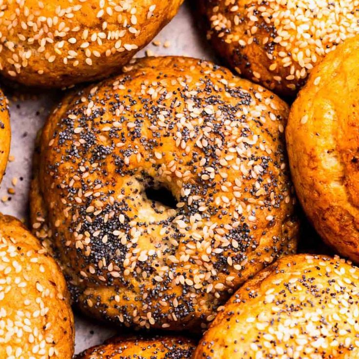 sesame seed bagels piled on top of each other