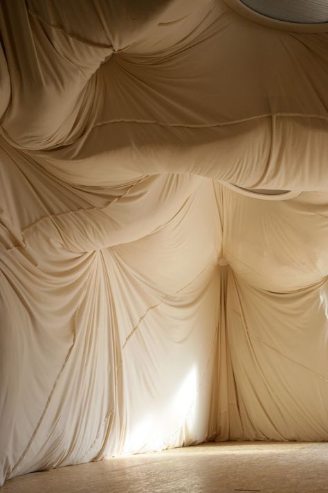 an empty room with drapes covering the walls