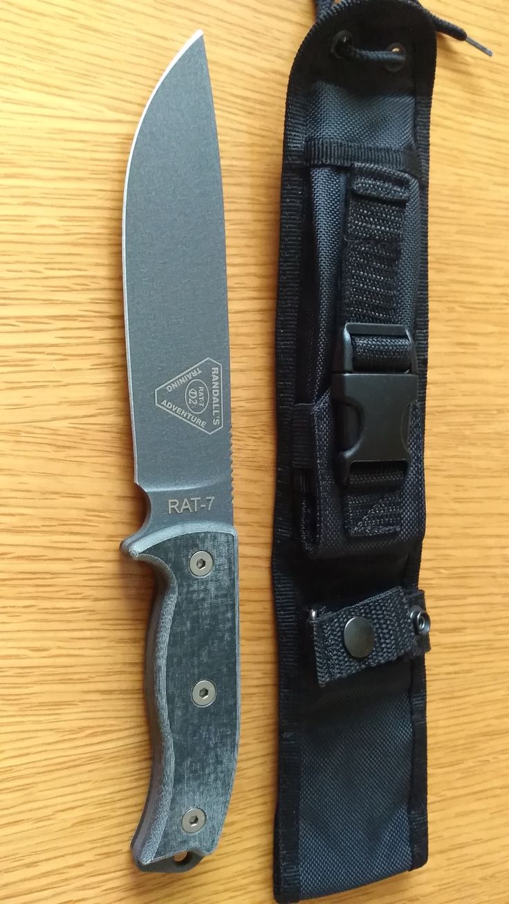 a knife and sheath sitting on top of a wooden table