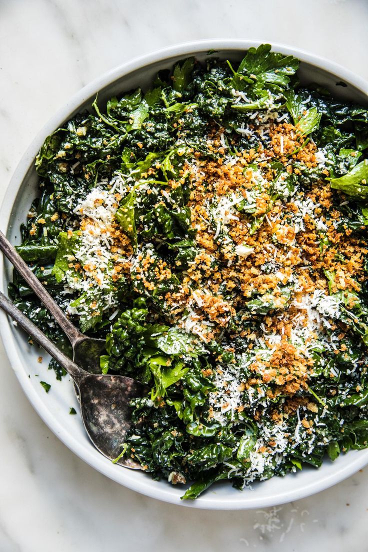 a white bowl filled with broccoli covered in parmesan cheese