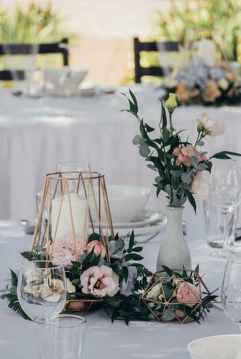 the table is set with flowers, candles and glass vases on top of it