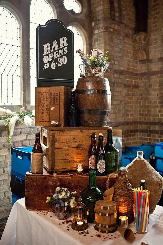 a table topped with lots of bottles and wooden crates