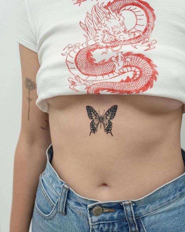 a woman's stomach with a dragon tattoo on the side and a butterfly on the other side