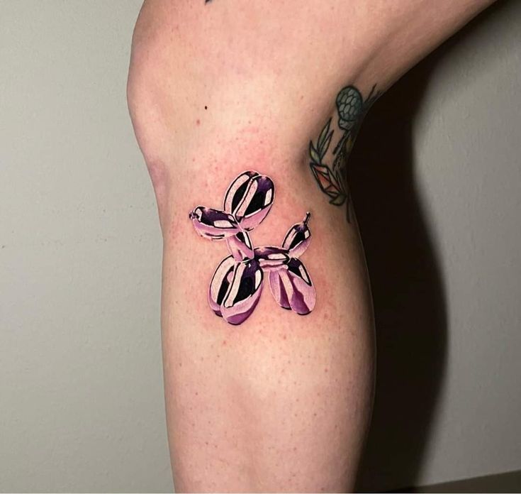 a woman's legs with tattoos on them and pink bows around the ankles, all over her body