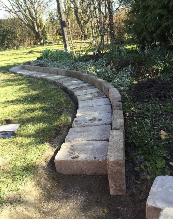 a stone path in the middle of a grassy area