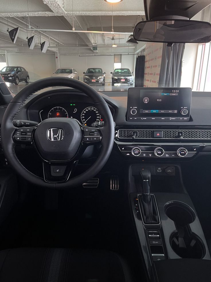 the inside of a car with dashboard, steering wheel and dash lights on display in a showroom