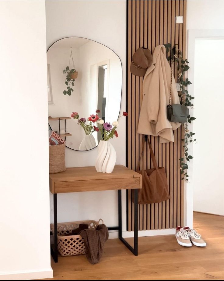 there is a coat rack and mirror in this room with shoes on the floor next to it