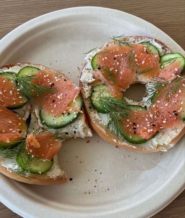 the bagel is topped with smoked salmon and cucumbers