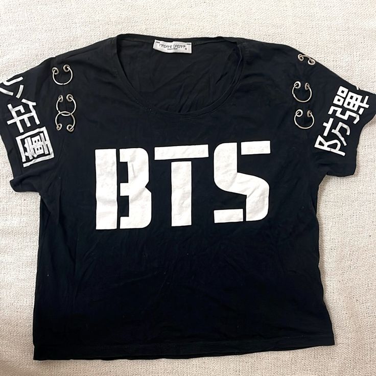 a black tshirt with white letters on the front and bottom that says bts