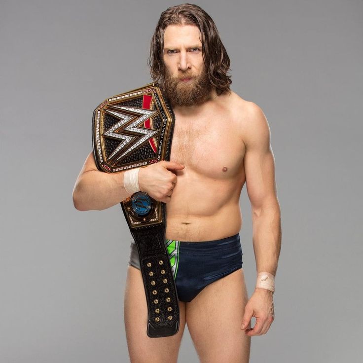 a man with a beard holding a wrestling belt