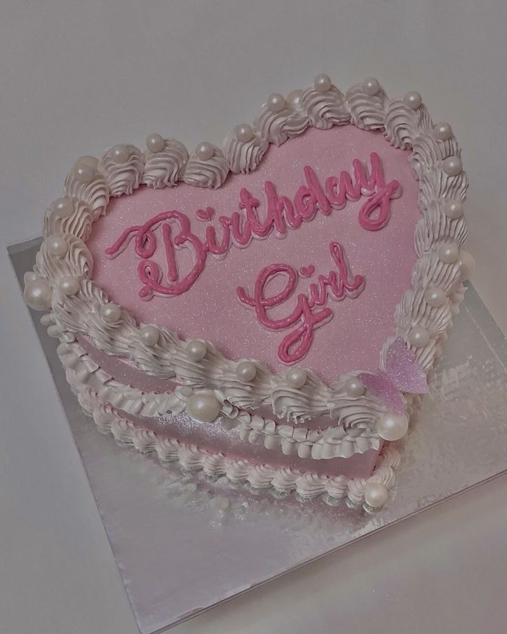 a heart shaped birthday cake with the words birthday girl written in pink frosting on it