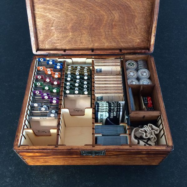 an open wooden box filled with lots of different types of dices and other items