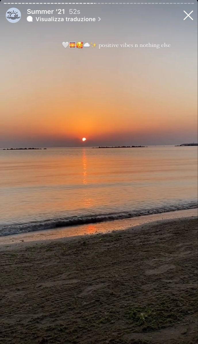 the sun is setting over the water at the beach in front of an ocean shore