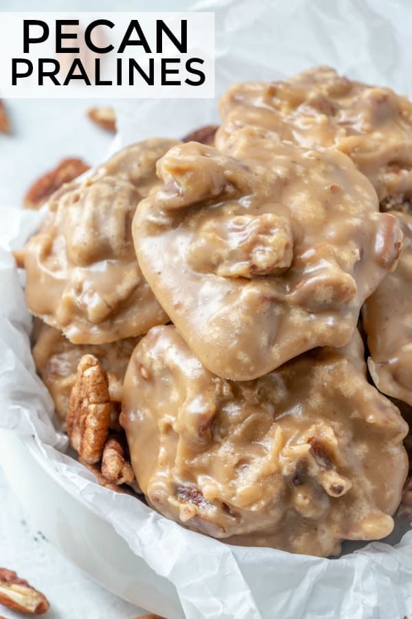 pecan pralies are piled on top of each other in a white bowl