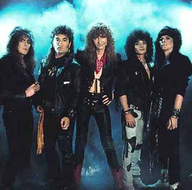 the group of rock band kiss posing for a photo in front of a blue background