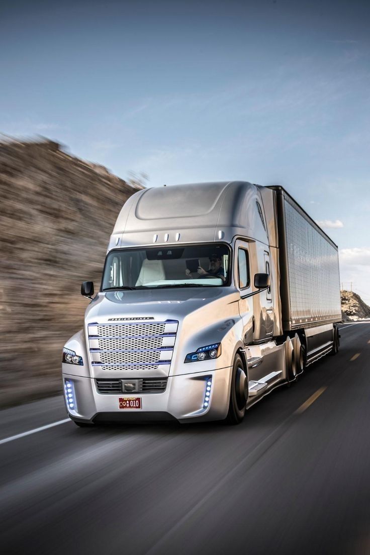 a silver semi truck driving down the road