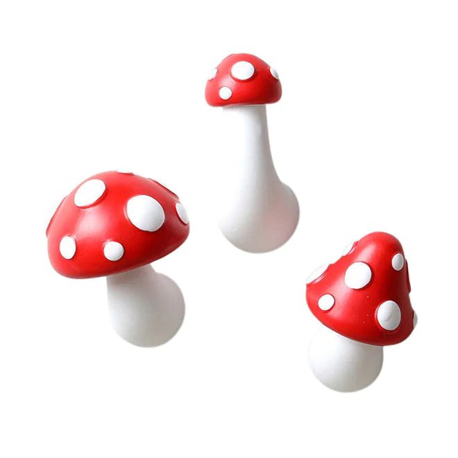 three red and white mushrooms are shown on a white background with one mushroom in the foreground