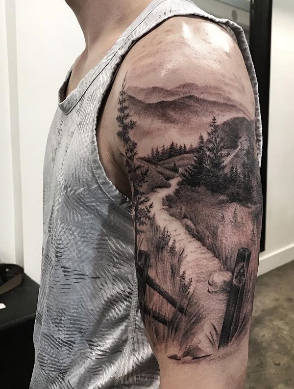 a man's arm with a landscape tattoo on the left side of his arm