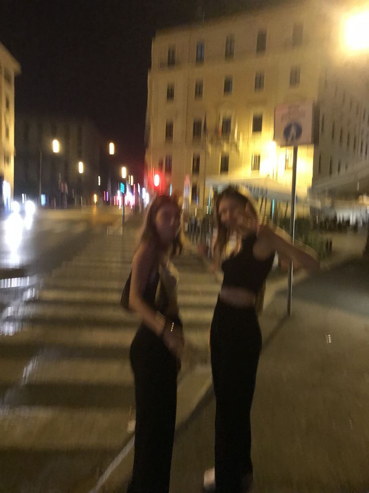 two women standing in the street at night