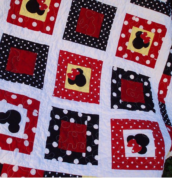 a red and white quilt with mickey mouses on it