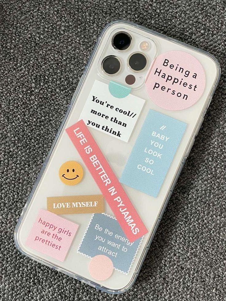 an iphone case with stickers on it sitting on top of a carpeted floor