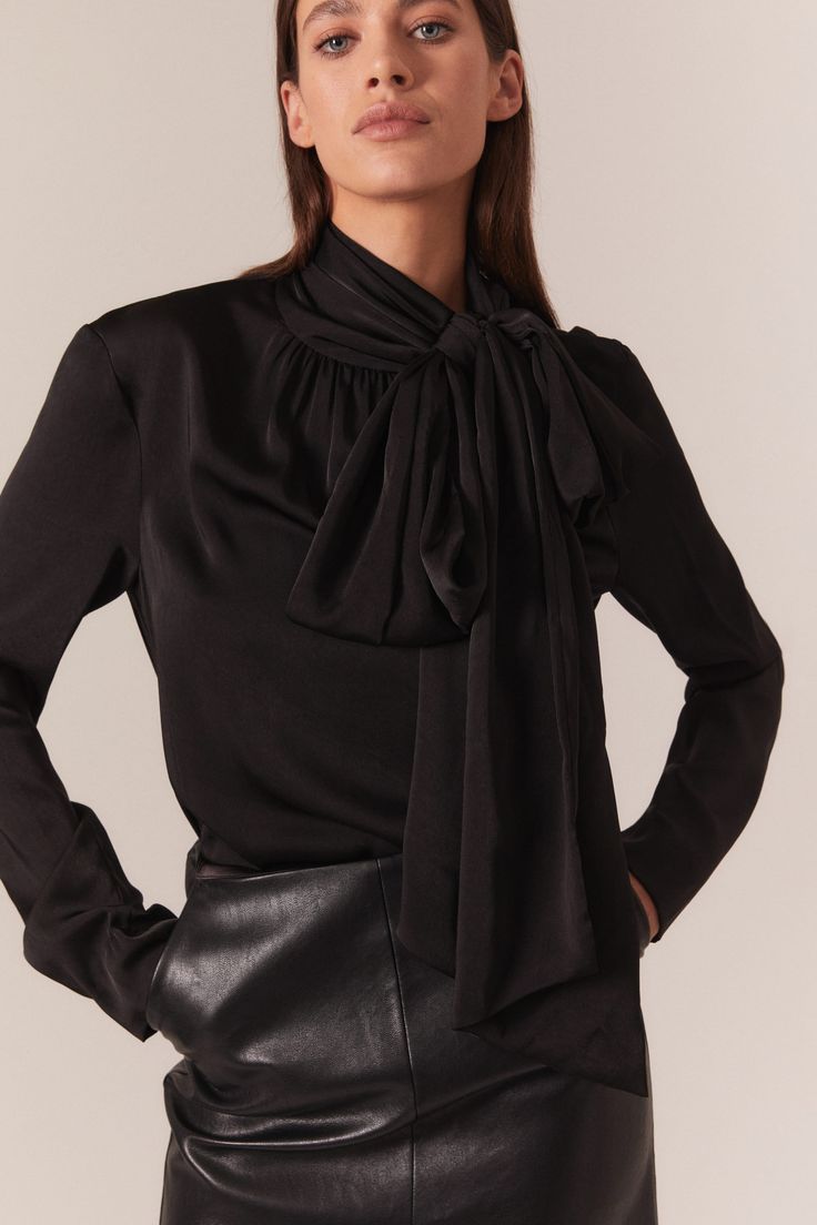 Trends with benefits. The Castian Satin Blouse has a relaxed silhouette that is dramatised by an exaggerated pussybow neckline. Imagined in classic black for a timeless and trans-seasonal look, this blouse is a work to weekend favourite.

SIZING: True to size. AU: Model wears a size 8 / US: Model wears a size 4.

FABRICATION: 100% Polyester

- Satin blouse
- Bow neckline with press stud
- Long loose sleeves Elegant Workwear Top With Bow Detail, Elegant Workwear Top With Bow, Elegant Tops With Bow For Workwear, Elegant Tie Neck Top For Night Out, Elegant Tie Neck Blouse For Work, Chic Blouse With Bow For Night Out, Silk Workwear Blouse With Bow, Chic Tie Neck Blouse For Night Out, Long Sleeve Evening Tops With Bow