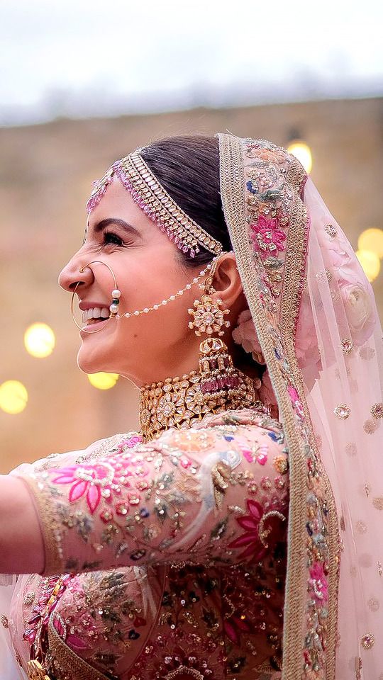 a woman in a bridal outfit smiles and holds her hand out to the side