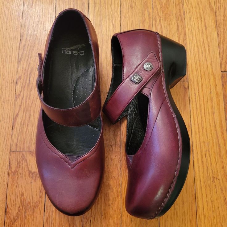 Elevate your style with these Dansko Mary Jane wedges. Crafted from durable leather, they offer both comfort and elegance. Ideal for daily wear. * Burgundy leather upper * Mary Jane strap with button detail * Cushioned insole for comfort * Wedge heel design * Size 41 (US Equivalent 10.5/11) Size: Womens 10.5 Measurements taken with item laid flat and are approx. Heel Height 2 in Marks and wear as shown.  Comfort Orthotic Plantar Fasciitis Comfy Comfortable Clog mule coastal grandmother coastal grandma normcore Academia Granny Grannycore Grandmacore Librarian Secretary Geek Nerd Nerdy Twee Preppy casual artsy Boho Hippie Chic Neutral Bohemian Festival Coachella Burning Man Rave Festivals Cottagecore Prairie Minimalist Sustainable Comfortable Leather Heels With Arch Support, Comfortable Leather Heels With Rubber Sole, Leather Round Toe Heels With Arch Support, Leather Heels With Arch Support And Round Toe, Leather Heels With Arch Support, Casual Style, Casual Leather Heels With Arch Support, Leather Clogs With Round Toe, Clogs With Arch Support And Round Toe, Comfortable Leather Heels With Round Toe