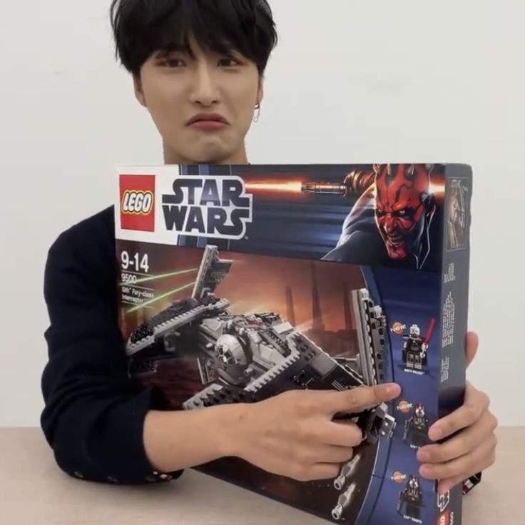 a man holding up a lego star wars box