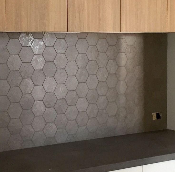 a kitchen counter top with wooden cabinets in the background and a tile backsplash