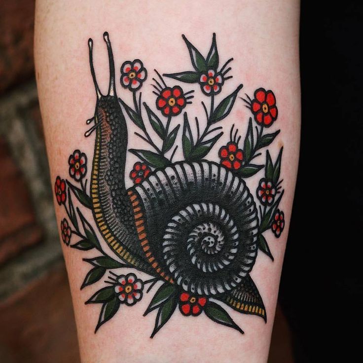 a tattoo with a snail and flowers on it