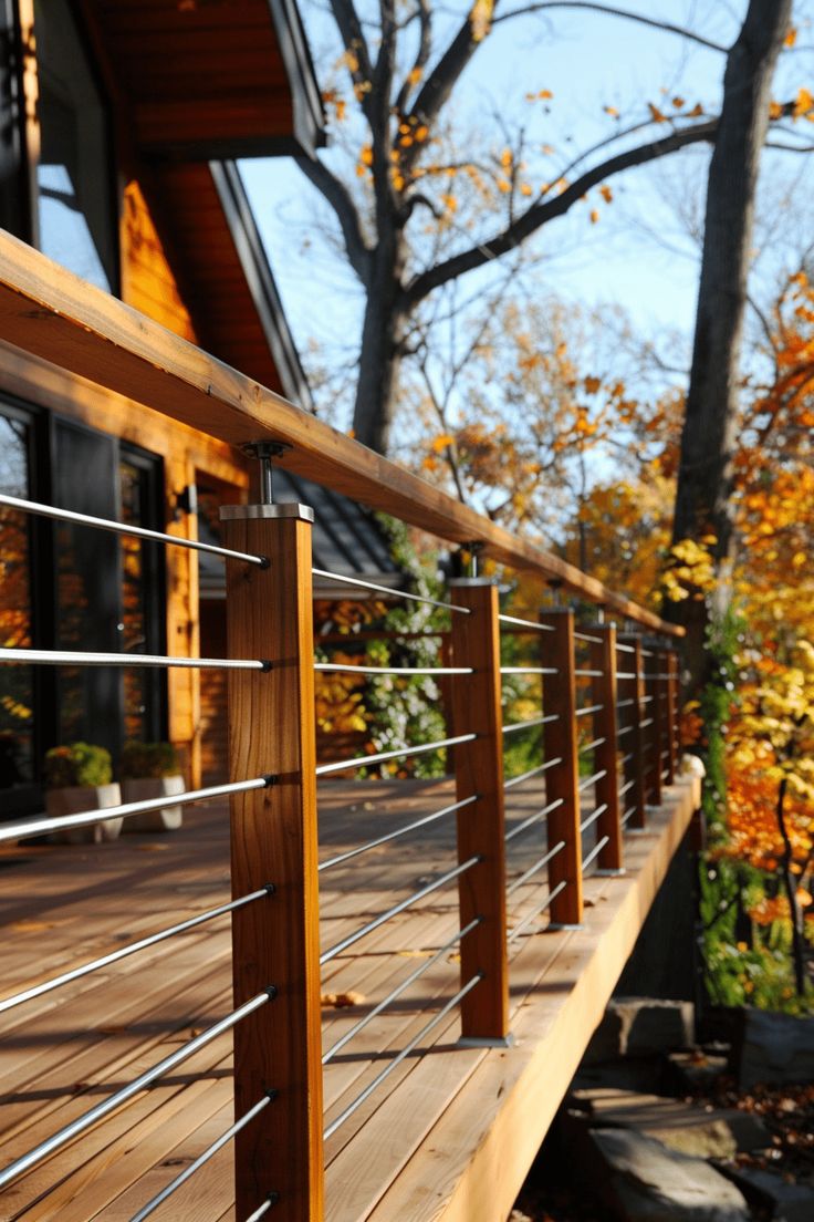 a wooden deck with metal railings in front of a house