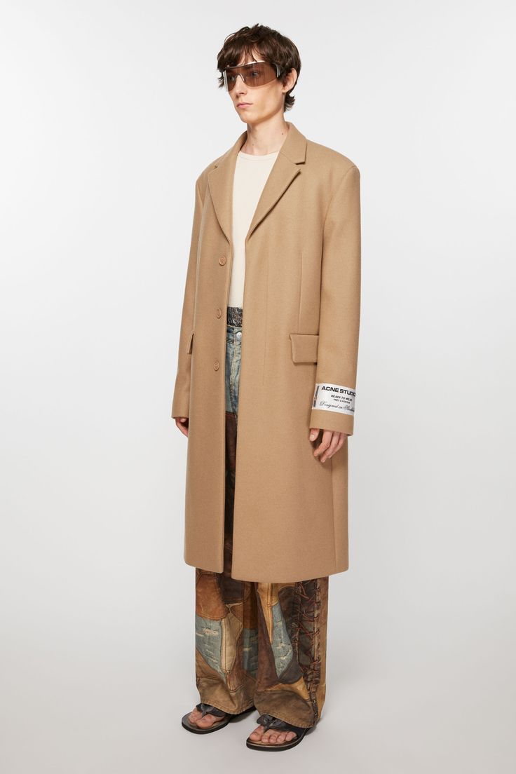 Single-breasted wool coat is cut to a regular fit and knee length. Complete with a concealed front closure and detailed with an Acne Studios Couture label. Crafted from a heavy wool blend. FN-MN-OUTW001039 Beige Wool Coat With Notch Lapel, Beige Notch Lapel Wool Coat, Designer Single Breasted Wool Coat With Notch Lapel, Designer Single Breasted Wool Coat For Work, Designer Single-breasted Wool Coat With Notch Lapel, Designer Single-breasted Wool Coat For Work, Designer Wool Coat With Notch Lapel For Work, Beige Wool Coat For Tailoring, Beige Wool Coat With Hidden Button Closure