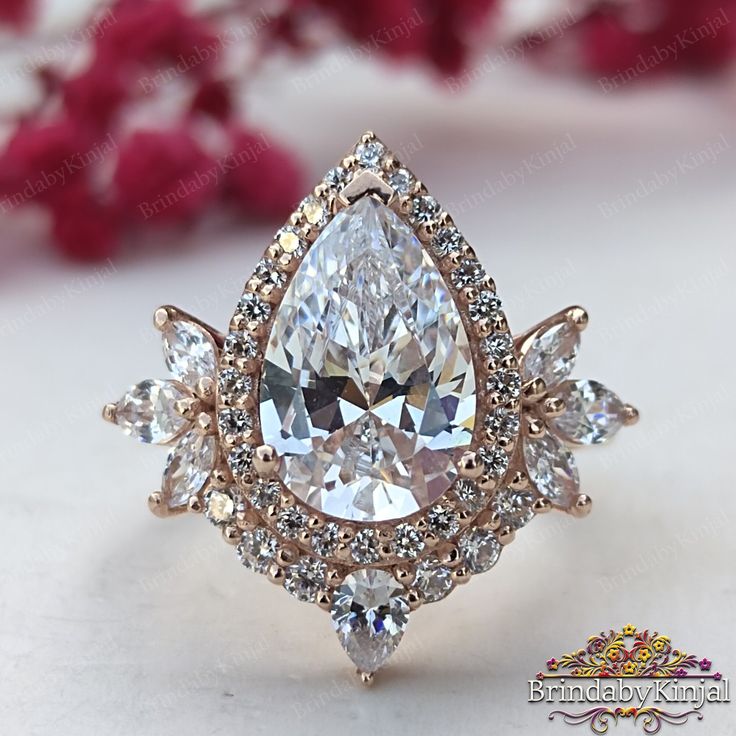 an engagement ring with three pear shaped diamonds in the center and side stones on each side