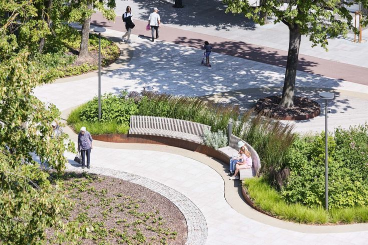 two people sitting on a bench in the middle of a park