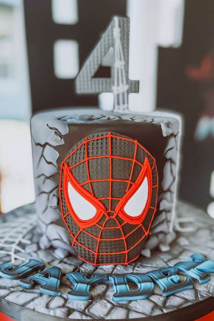 a spiderman birthday cake with the number four on it's face and eyes