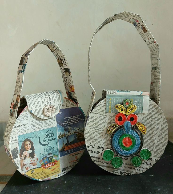 two purses made out of newspaper are sitting on a table