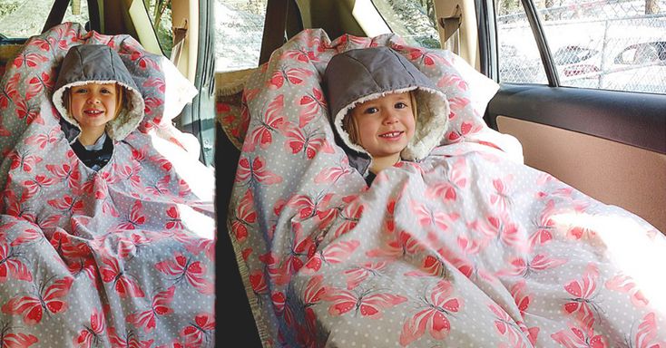 two young children sitting in the back seat of a car wearing blankets and ponchies