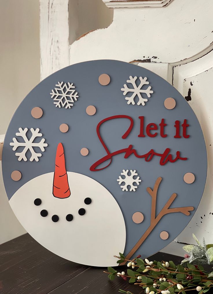 This beautiful 16 round canvas Let It Snow Snowman sign makes a great added decor piece to any home, or as a gift.  All elements are 3D cutouts.  Not intended to be used in direct line of outdoor elements. Blue Gray Background, Blue Let It Snow Wood Sign, Wood Lettering, Let It Snow Snowman, Mini Easel, Farmhouse Wood Sign, Mini Pink, Round Canvas, Storm Door