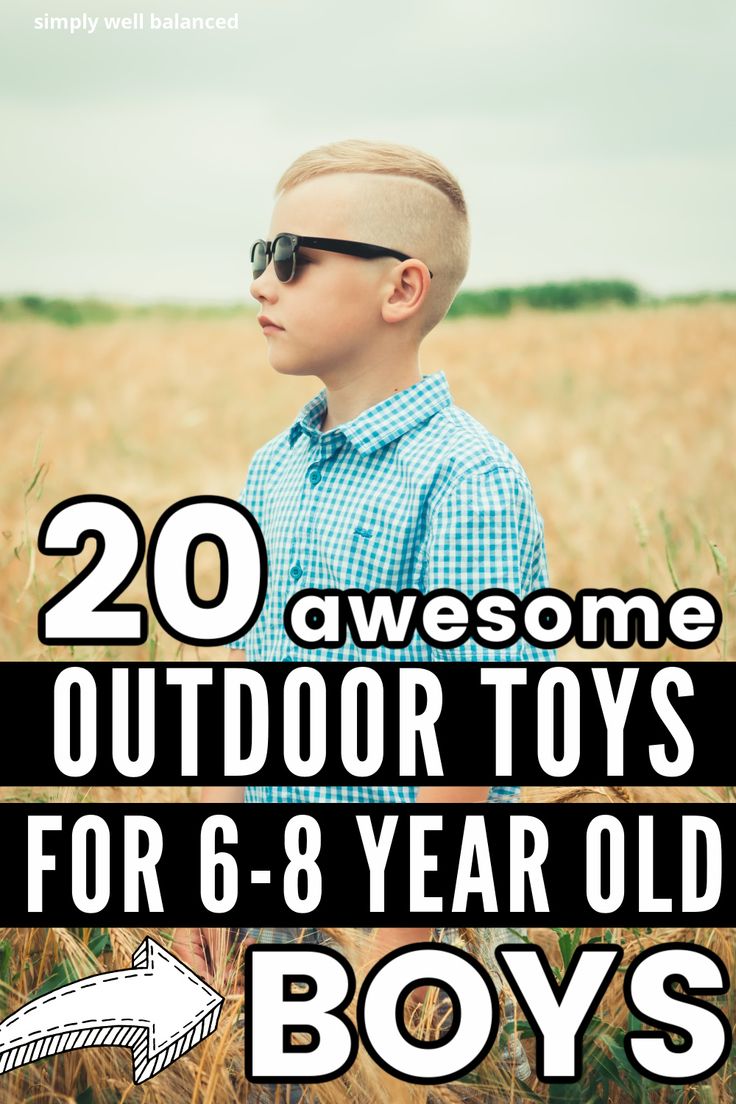 a young boy with sunglasses standing in a field