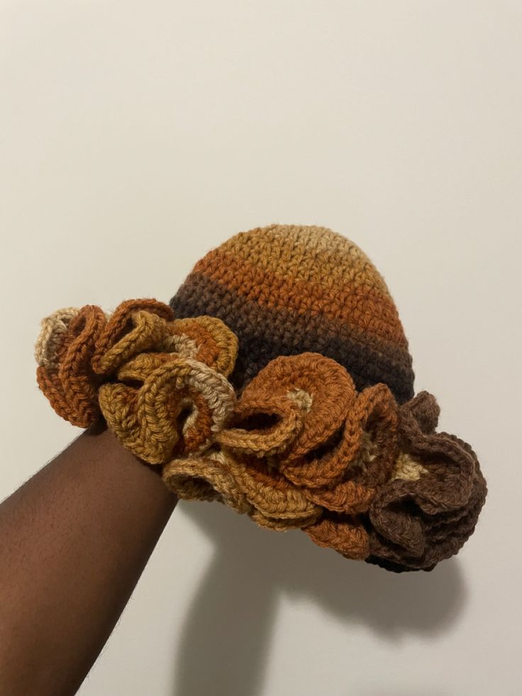 a hand is holding onto a crocheted hat