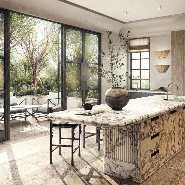 a large kitchen with marble counter tops next to sliding glass doors and an outdoor dining area